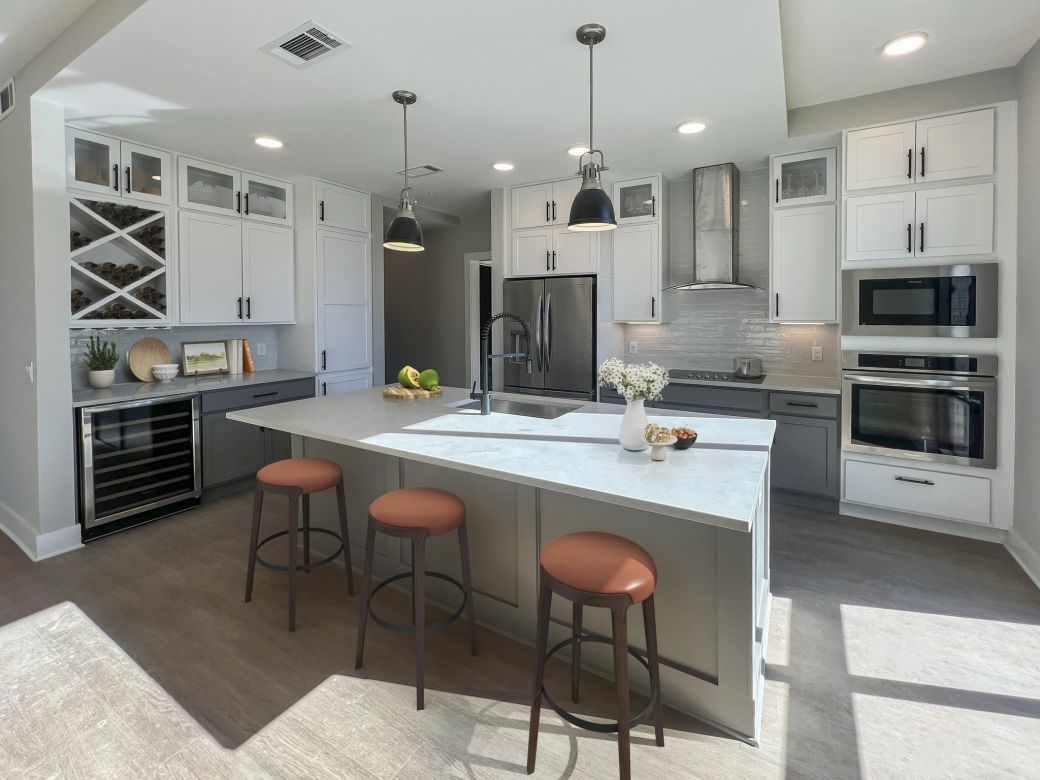 Carraway Village kitchen with large island, quartz countertops, gourmet stainless steel appliances, and custom cabinets