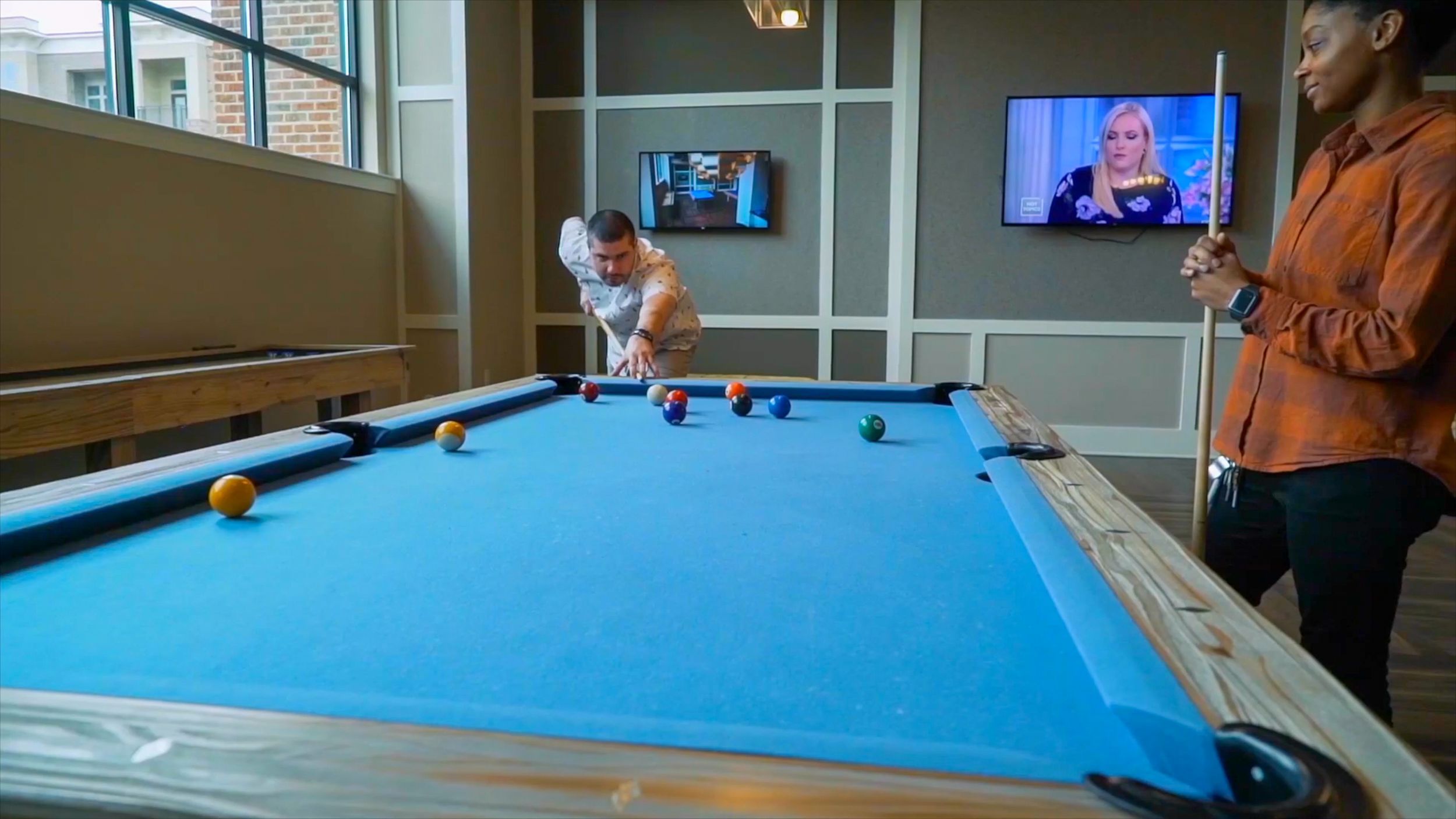 Billiards table and shuffleboard table inside game room amenity at Carraway Village Apartments in Chapel Hill, NC