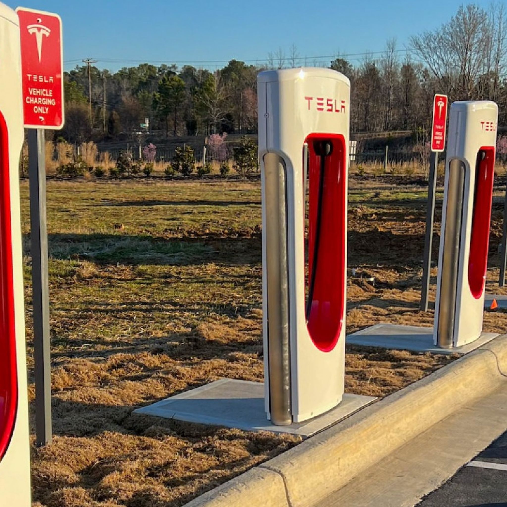 Tesla charging stations outdoors in parking lot at Carraway Village Apartments