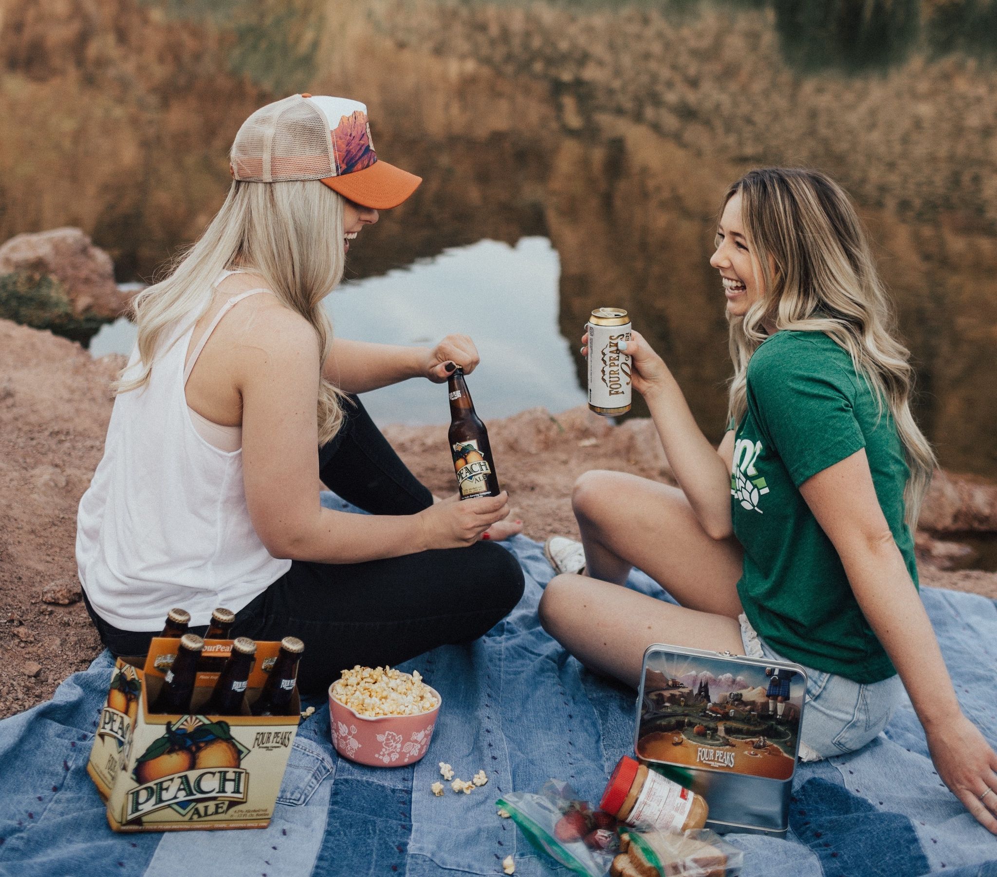 Two girls having a picnic outdoors with food and drinks