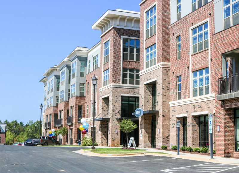 Exterior of Carraway Village Apartments showing apartment building and parking lot