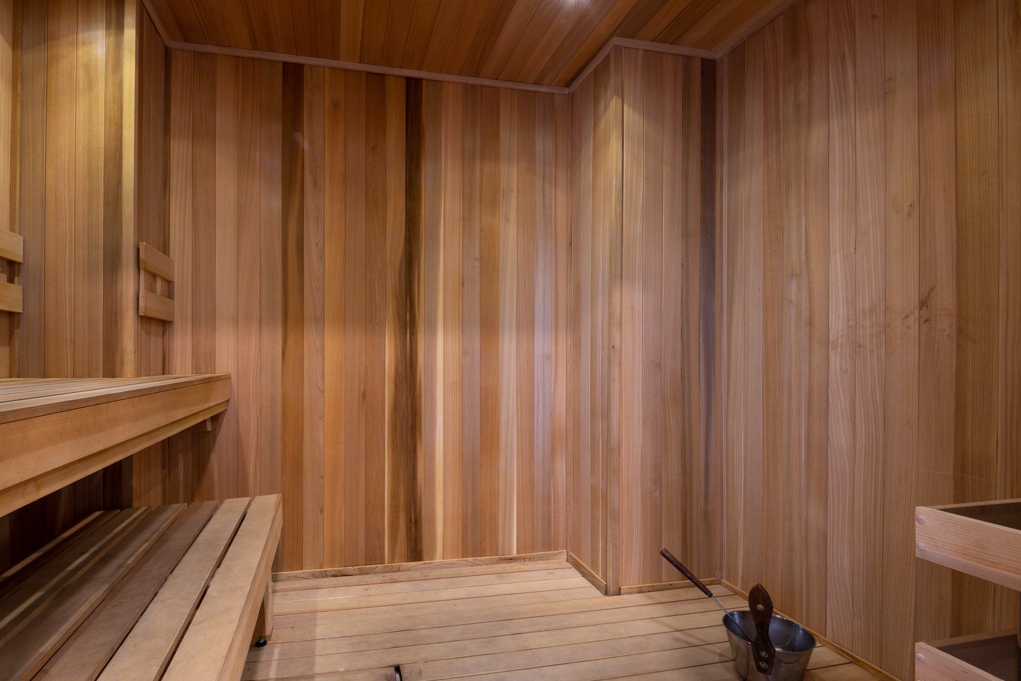 Sauna room with bench and wood flooring and walls