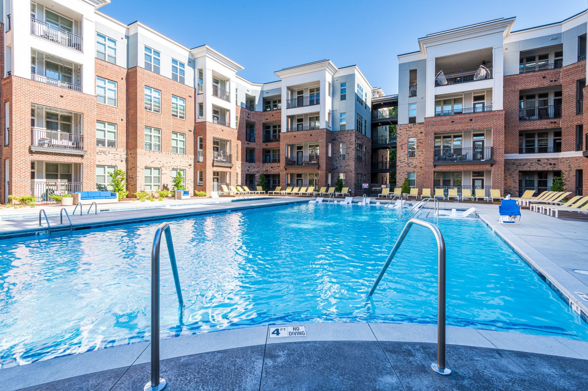 Luxury outdoor pool with lounge seating at Carraway Village Apartments