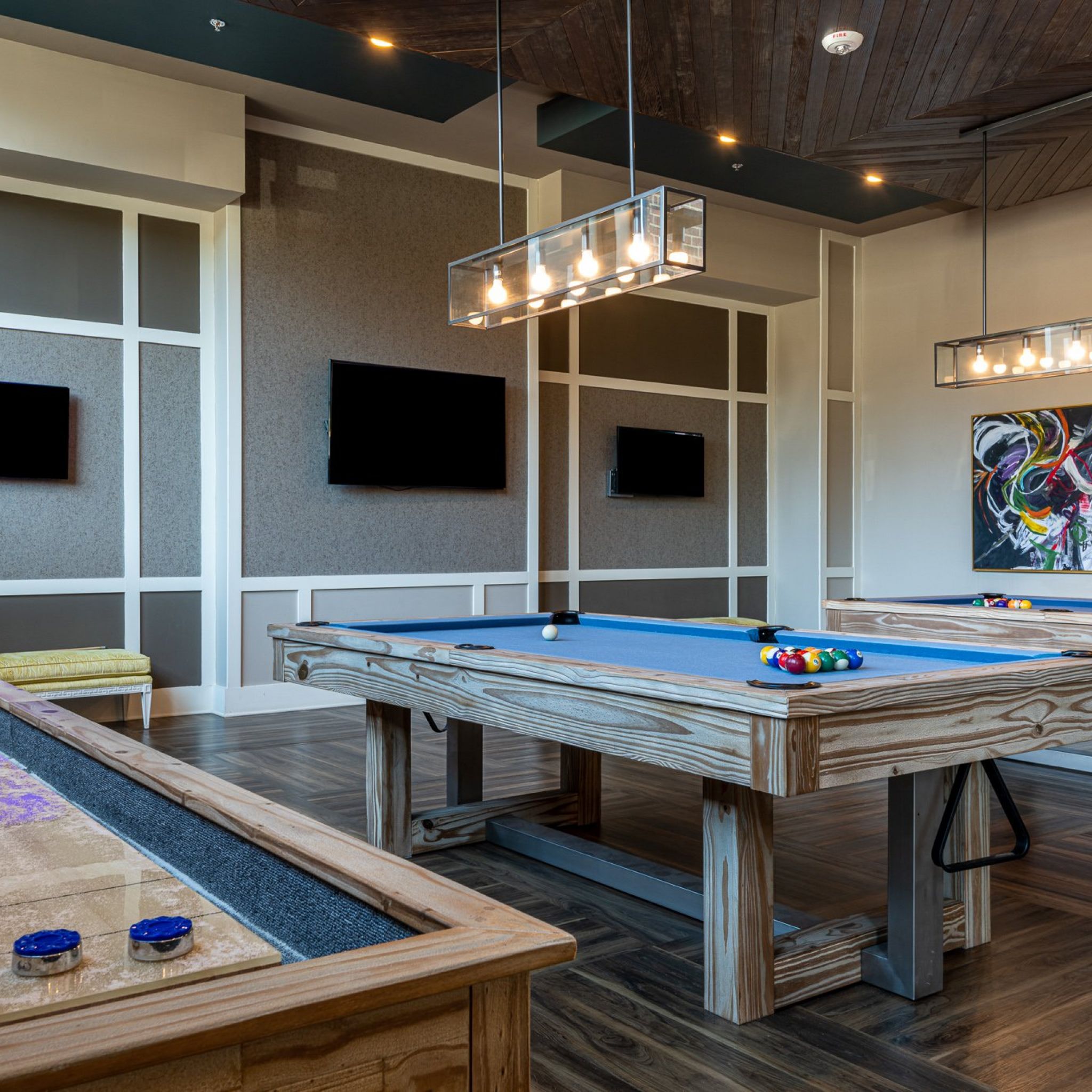 Billiards table and shuffleboard table inside game room amenity at Carraway Village Apartments in Chapel Hill, NC