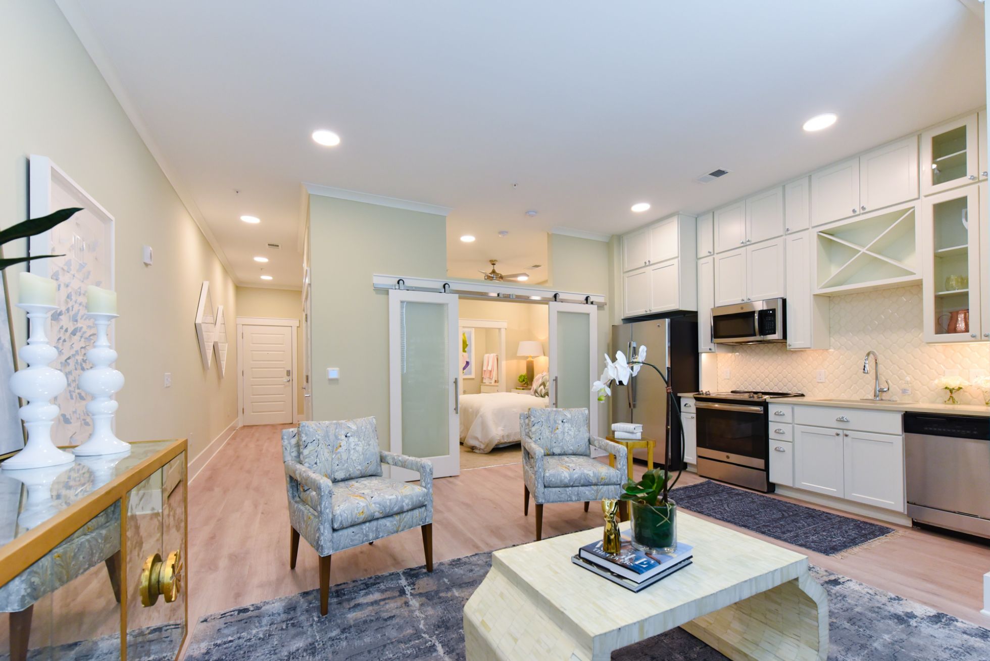 Virtually staged living and dining area with large windows, luxury hard-wood flooring, and high-end finishes