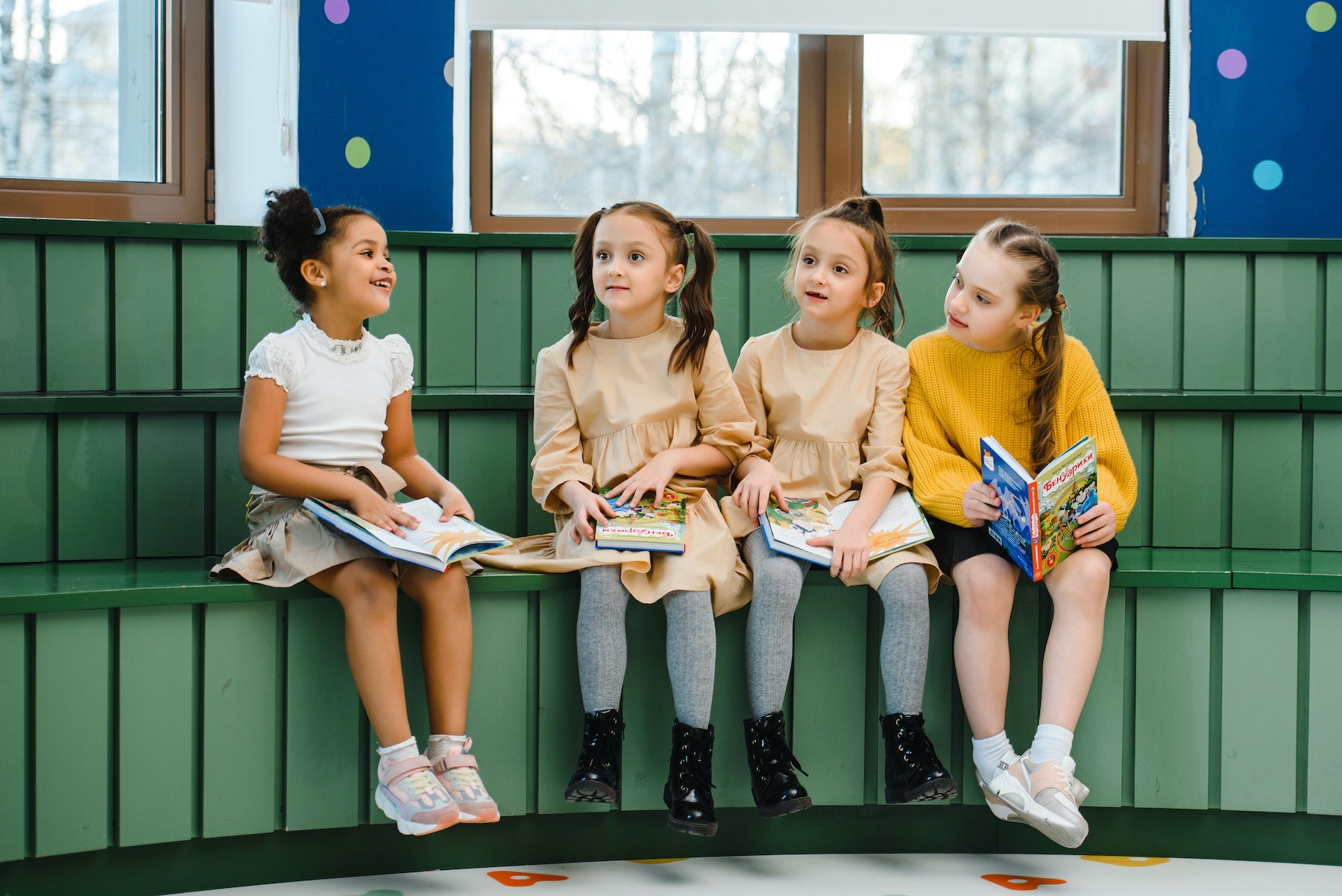 Four elementary school girls sitting and reading together