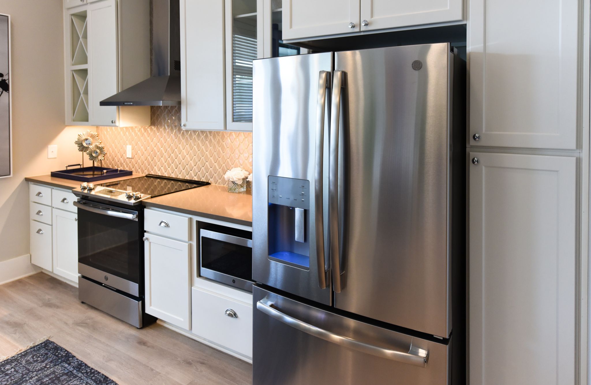 Studio apartment kitchen with stainless steel appliances, built-in wine storage, and small dining table