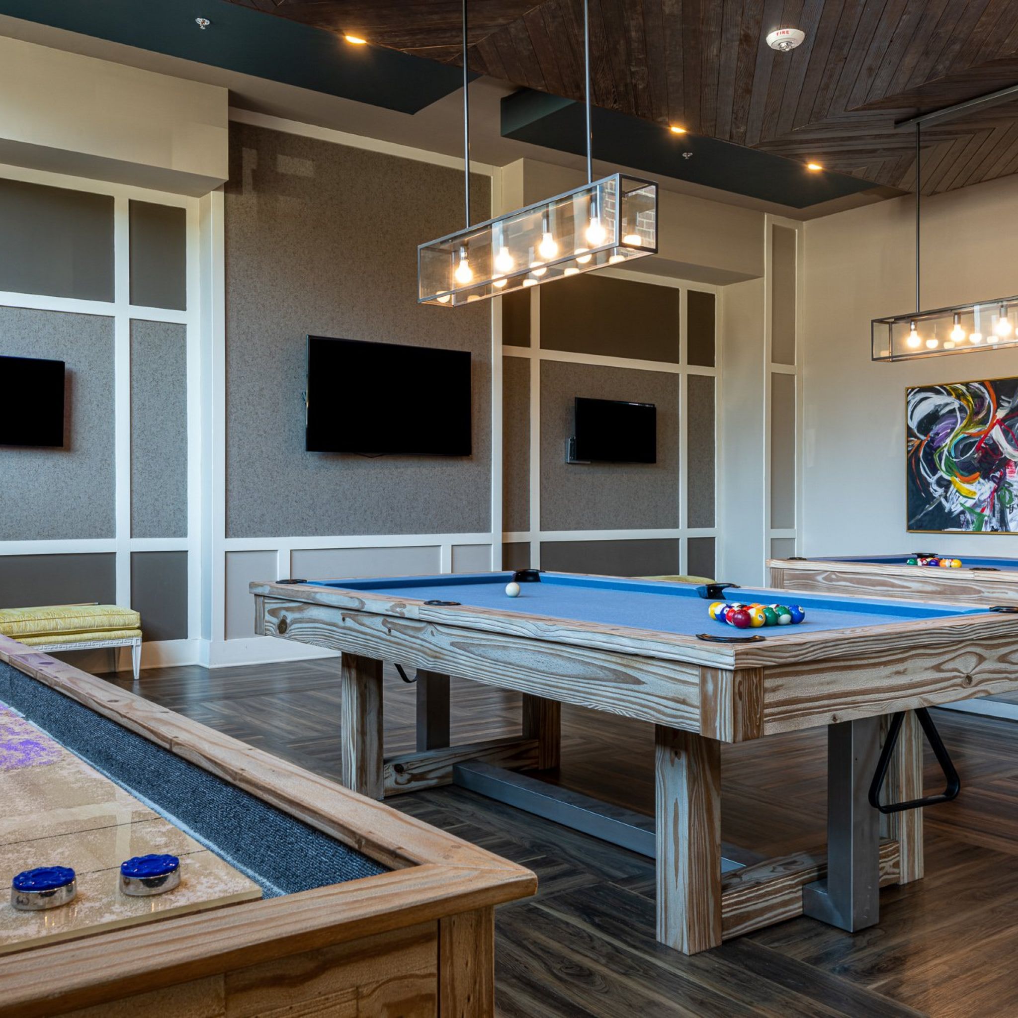 Billiards table and shuffleboard table inside game room amenity at Carraway Village Apartments in Chapel Hill, NC